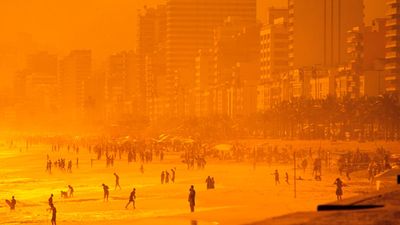 Beach. Sand. Ocean. Vacation. Sunset casts an orange glow over Ipanema Beach, Rio de Janeiro, Brazil.