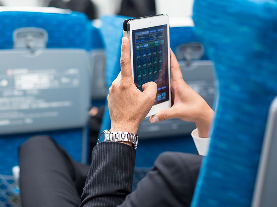 Businessman using tablet phone on airplane