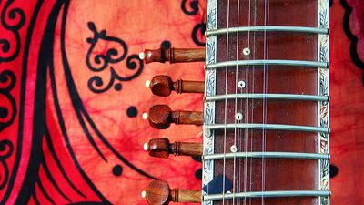 Close-up of an old sitar against a colorful background. (music, India)