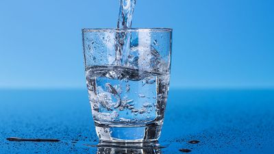 Drinking water is poured into a glass.