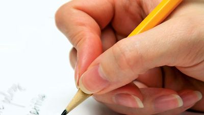 Hand with pencil writing on page. (handwriting; write)