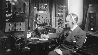 Italian physicist Guglielmo Marconi at work in the wireless room of his yacht Electra, c. 1920.