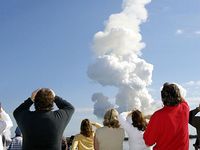 After a perfect launch, spectators try to catch a last glimpse of Space Shuttle Columbia, barely visible at the top end of the twisted column of smoke.