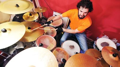 Dummer playing with his drum set or drum kit.