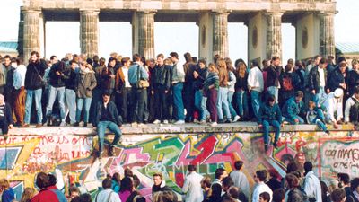 Germans from East and West stand on the Berlin Wall in front of the Brandenburg Gate in the November 10, 1989, photo, one day after the wall opened.