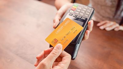 Person paying with a credit card using a credit card terminal. Cashless payment, credit card reader