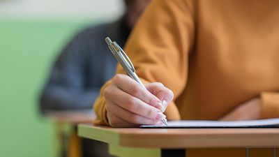 Students taking exam in classroom (testing, school, education).